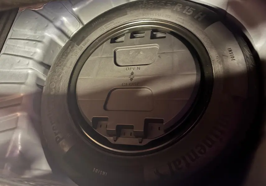 Gros plan sur la roue de secours dans le coffre d'une Renault Clio gris 2020, montrant le pneu Continental et son boîtier central.