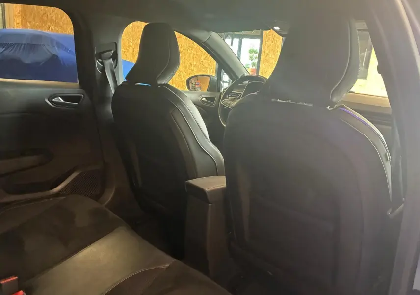 Vue intérieure arrière de la Renault Clio 2020 gris, montrant les sièges avant en tissu noir et la console centrale.