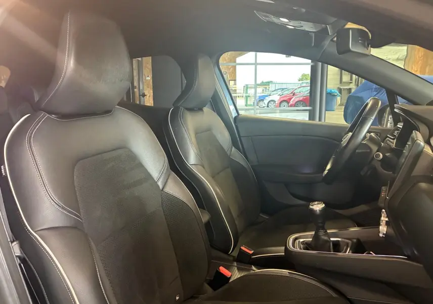 Intérieur de la Renault Clio 1.0 TCE 100 Intens 2020 montrant les sièges avant en tissu noir et volant multifonction.