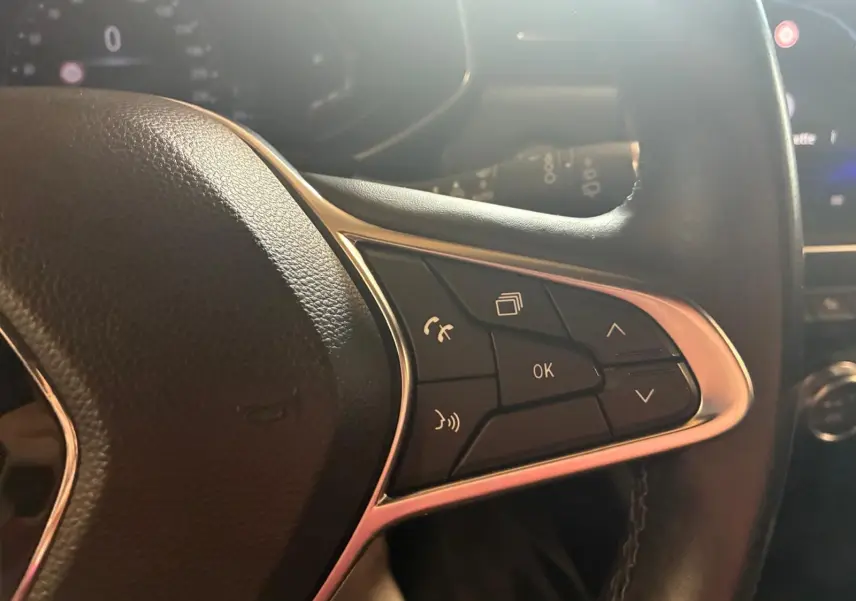 Gros plan sur les commandes multifonctions à droite du volant d'une Renault Clio gris 2020, finition Intens.