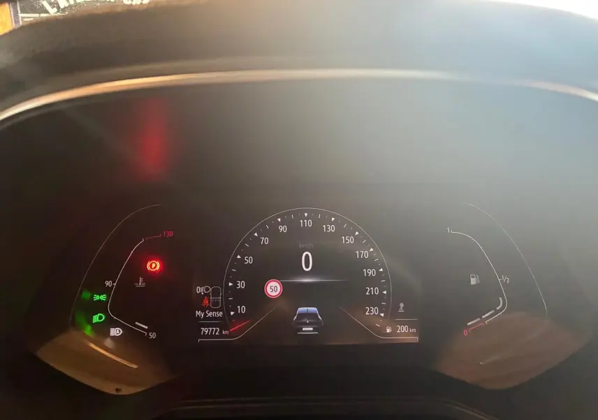 Tableau de bord numérique de Renault Clio 2020 gris, affichant la vitesse à 0 km/h et témoins allumés.