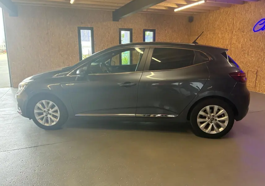 Profil côté gauche d'une Renault Clio gris métallisé 2020, compacte cinq portes avec jantes alliage et vitres teintées.