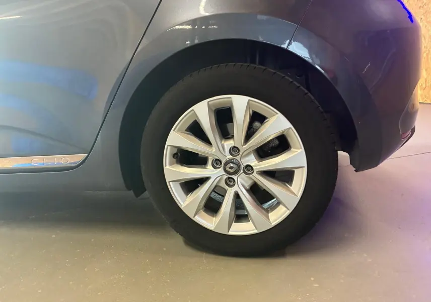 Gros plan sur la roue arrière droite gris métallisé d'une Renault Clio 1.0 TCE 100 Intens avec jante alliage et logo Renault.