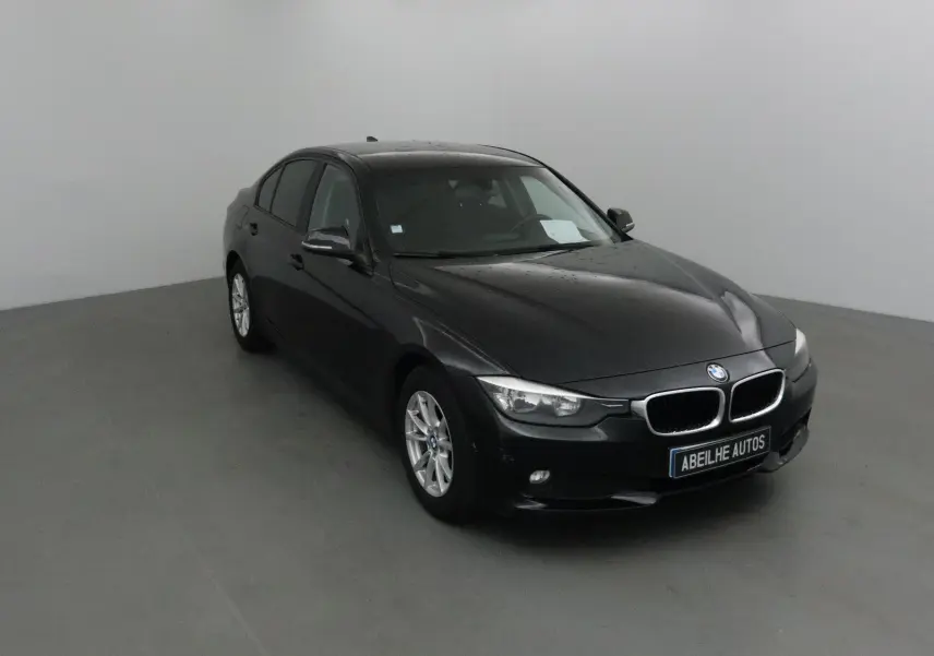 BMW Série 3 316D noire vue en 3/4 avant droit, avec jantes alliage et calandre caractéristique BMW.