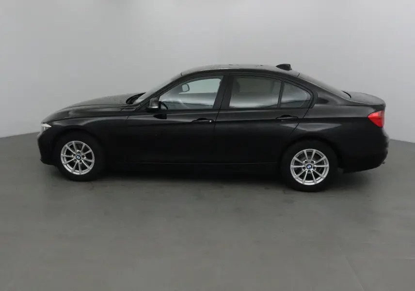 BMW Série 3 316d noire vue de profil côté gauche, berline compacte avec jantes alliage argentées.