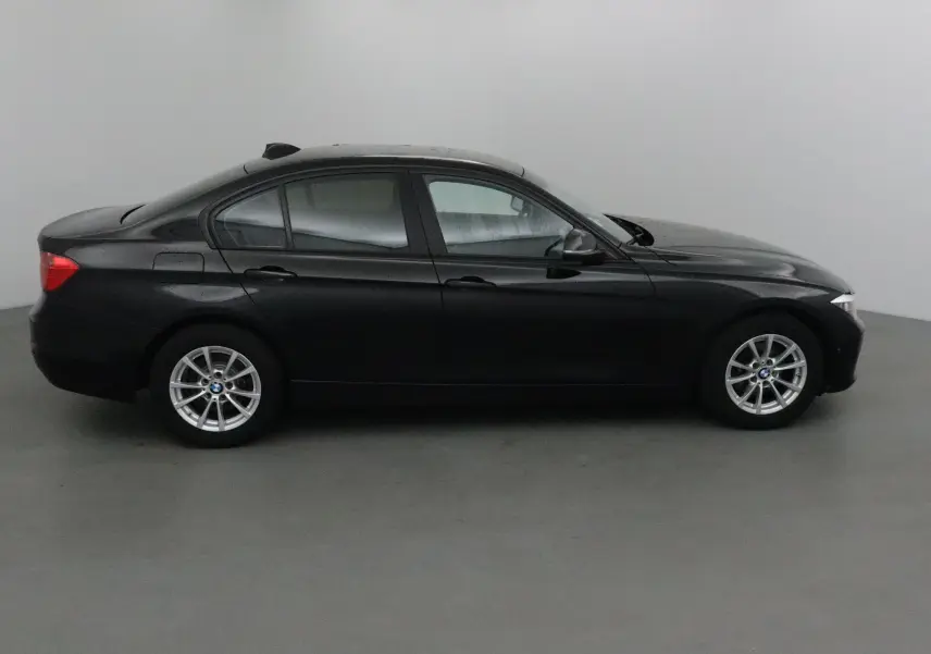 Profil côté gauche d'une BMW Série 3 316D noire de 2014 avec jantes alliage et rétroviseurs électriques.