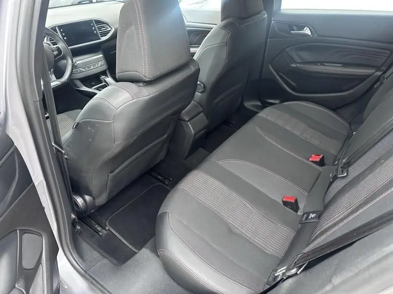 Vue intérieure côté arrière droit de la Peugeot 308 gris métal 2019, montrant les sièges arrière et partie avant.