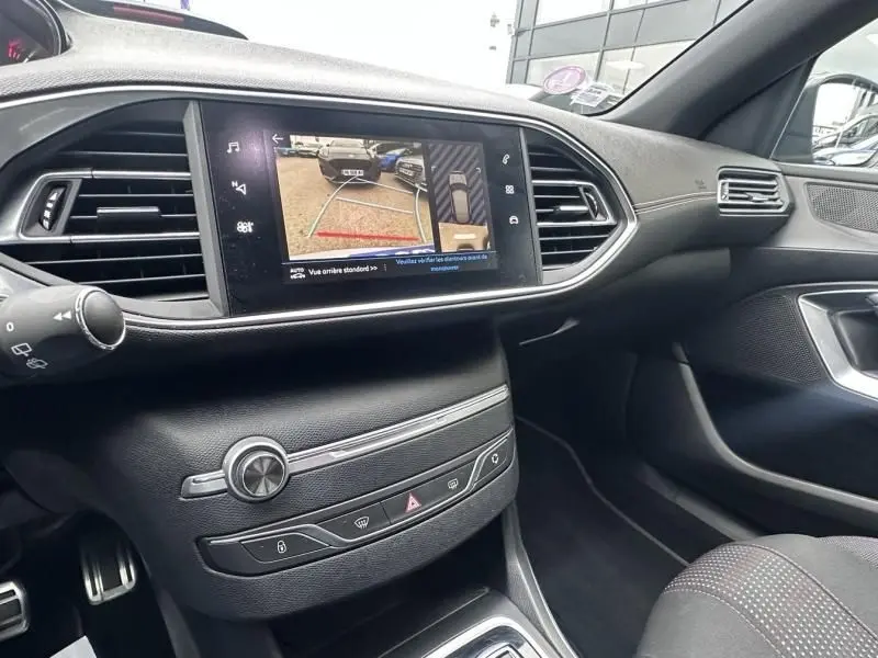 Vue intérieure du tableau de bord de la Peugeot 308 gris métal 2019, avec écran tactile affichant la caméra de recul.
