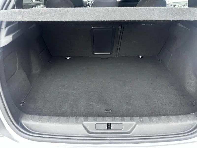 Vue du coffre ouvert d'une Peugeot 308 gris métal 2019, montrant un espace de rangement propre et spacieux.