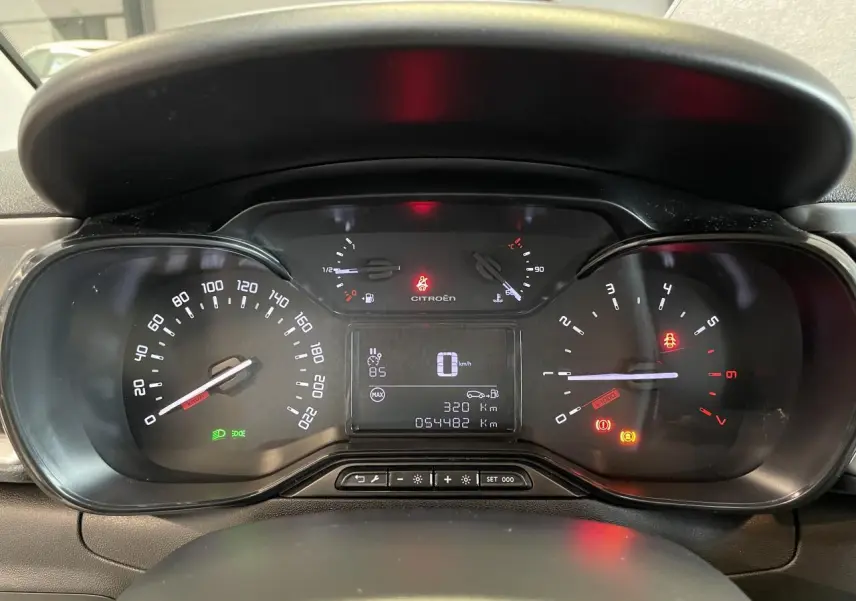 Vue rapprochée du tableau de bord numérique de la Citroën C3 blanche, affichant le compteur et les voyants allumés.