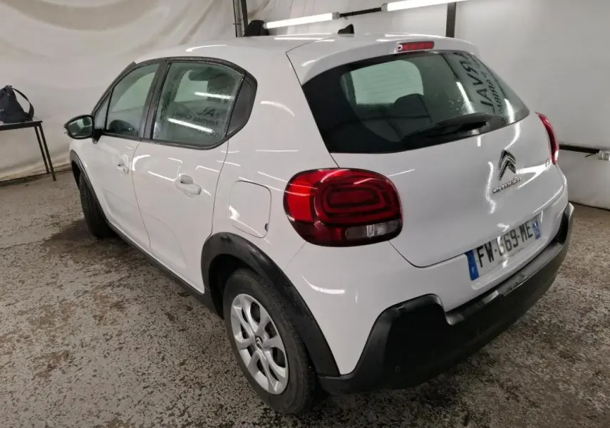 Vue 3/4 arrière droite d'une Citroën C3 blanche avec élargisseurs d'ailes noirs et feux arrière 3D dans un garage.