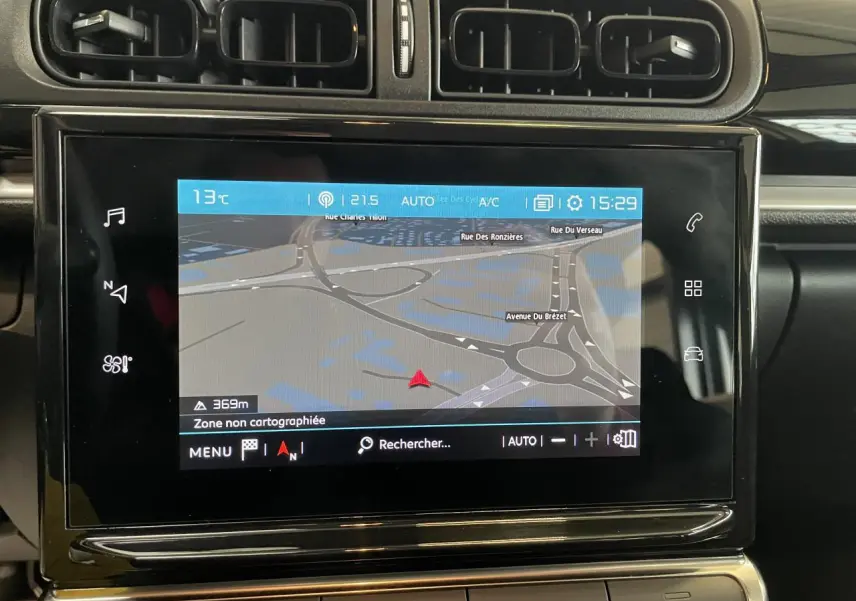 Écran tactile central avec navigation affichée sur tableau de bord noir brillant de Citroën C3 blanc, vue intérieure frontale.