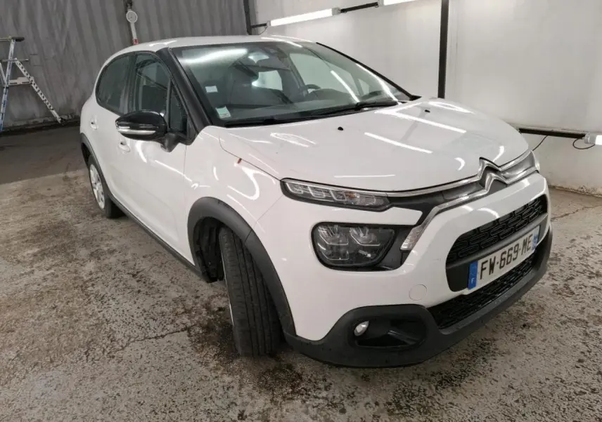 Citroën C3 blanc vue 3/4 avant droit avec coques de rétroviseurs noires et élargisseurs d'ailes noirs.