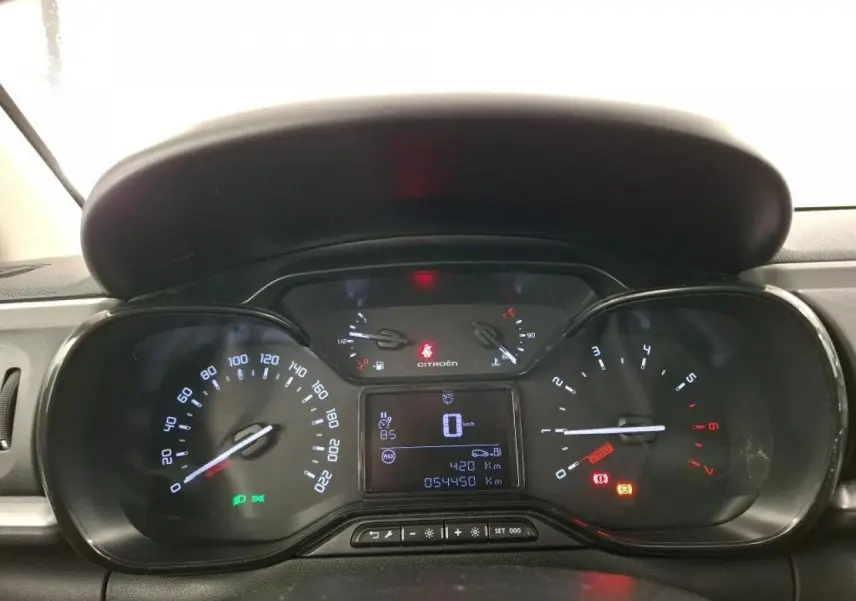 Vue rapprochée du tableau de bord de la Citroën C3 blanche, affichant le compteur et les voyants allumés.