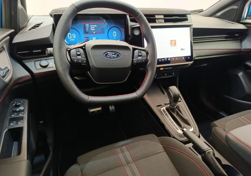 Vue intérieure avant du Ford Puma bleu 2025, volant cuir noir, écran tactile central et affichage numérique.