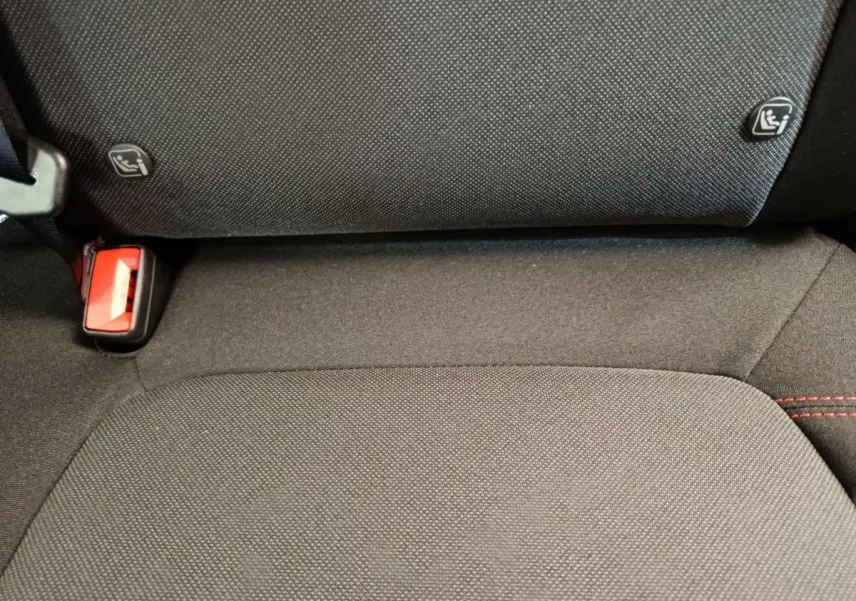 Gros plan sur la banquette arrière noire du Ford Puma 2025 avec fixation Isofix et boucle de ceinture rouge visible.