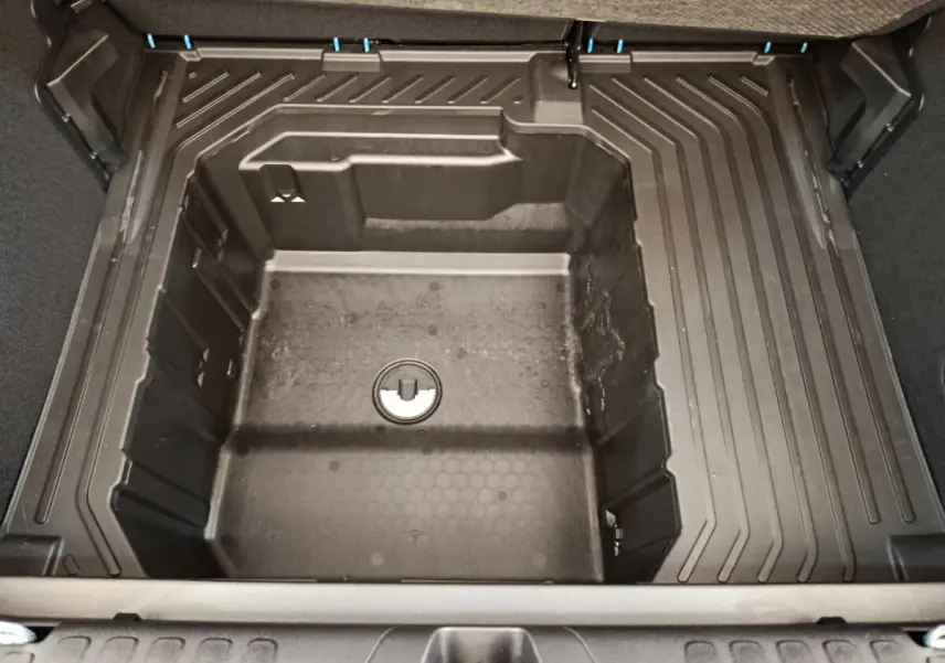 Coffre ouvert en vue plongeante du Ford Puma bleu 2025, montrant le compartiment de rangement sous tablette.