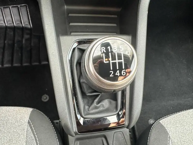 Le levier de vitesse manuel de la Renault Clio 2025 en gros plan, avec marquage des vitesses sur fond noir brillant.