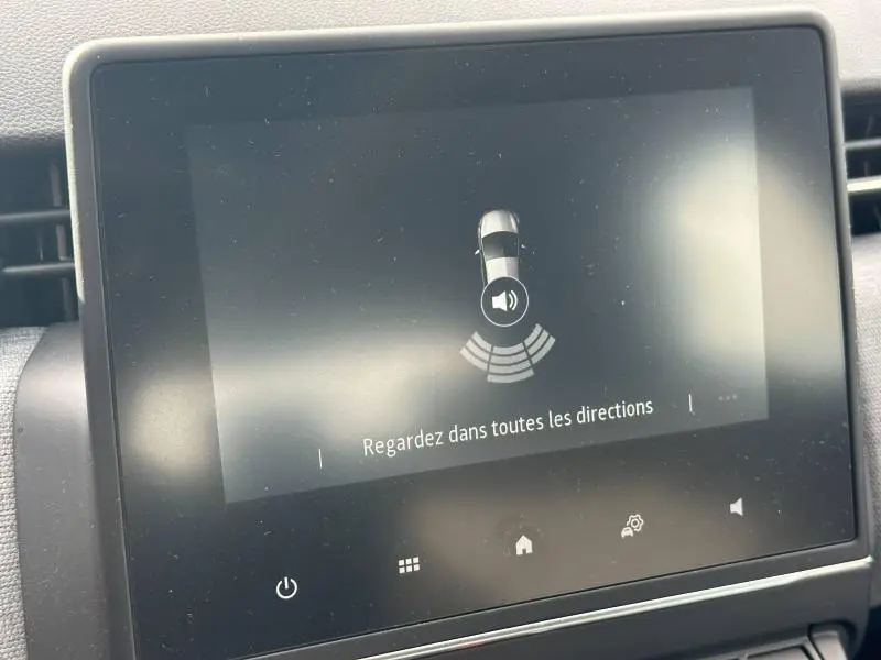 Écran tactile intérieur de la Renault Clio 2025 affichant l'alerte de détection d'obstacles avec message en français.