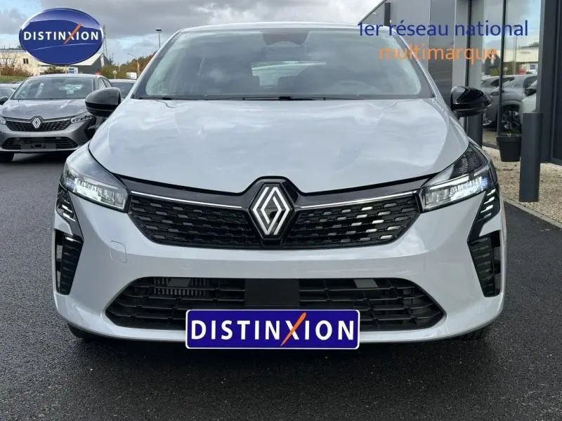 Vue avant d'une Renault Clio 1.0 TCe 90ch Evolution 2025 gris clair avec calandre noire et logo central lumineux.