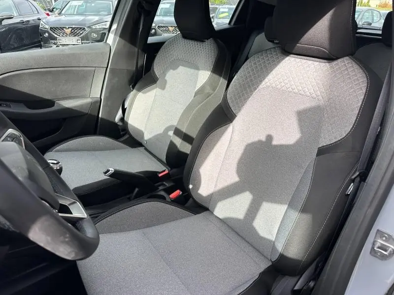Intérieur de la Renault Clio 2025, vue côté conducteur, sièges tissu gris clair avec motifs géométriques.