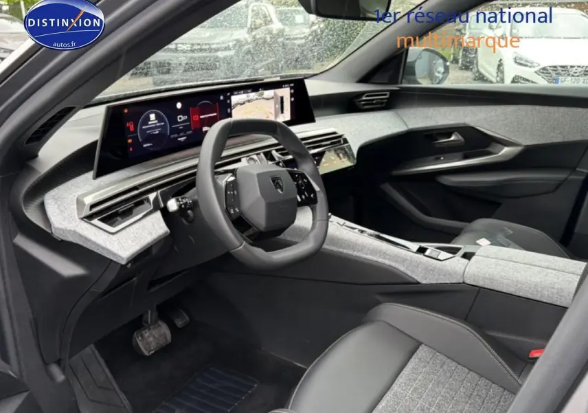 Vue intérieure côté conducteur du Peugeot 5008 Hybrid 145 allure e-dcs6 2025 avec tableau de bord numérique et sellerie gris clair.