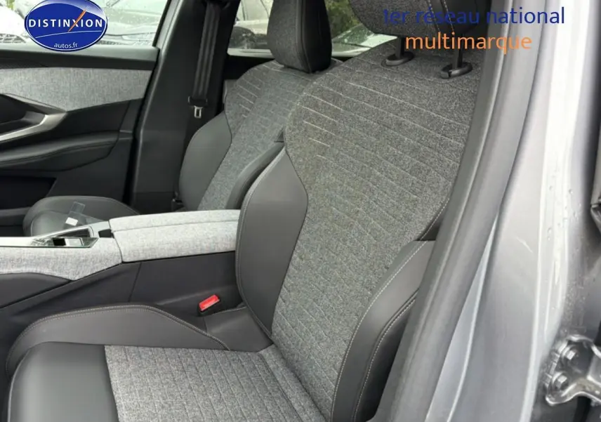 Gros plan sur les sièges avant gris tissu et cuir du Peugeot 5008 Hybrid 145 allure e-dcs6, avec accoudoir central.