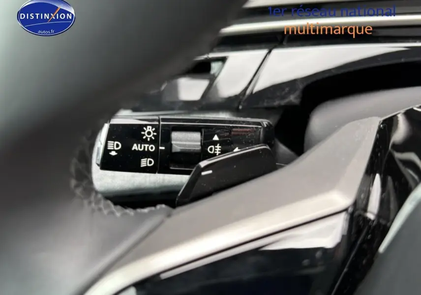 Gros plan sur la commande des phares automatique à gauche du volant du Peugeot 5008 gris Artense 2025.