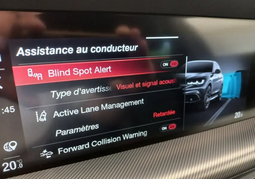 Écran tactile intérieur montrant les aides à la conduite avec illustration d’un Alfa Romeo Stelvio gris foncé en vue 3/4 avant.