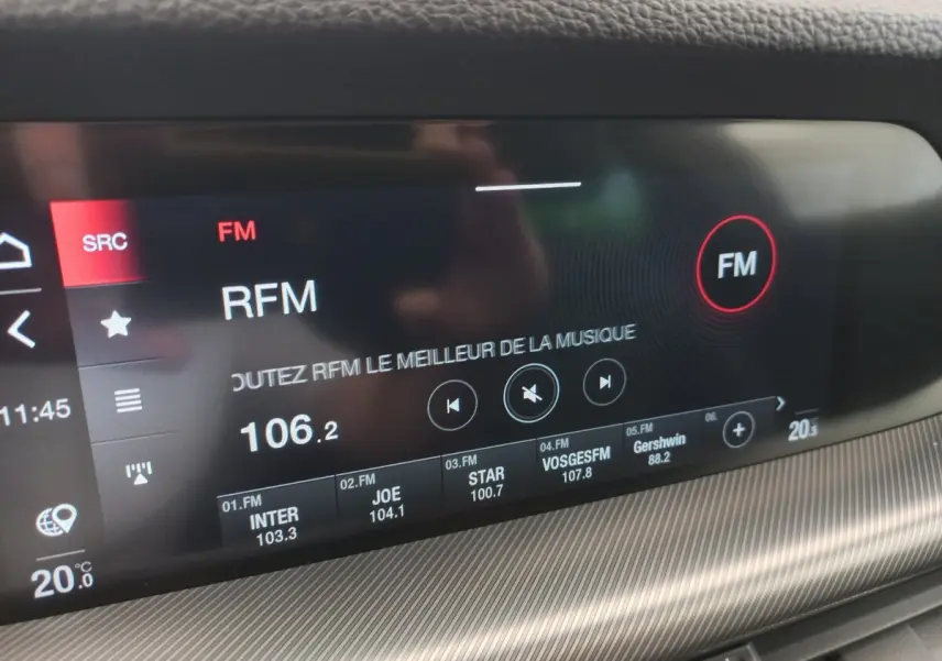 Gros plan sur l'écran tactile central du tableau de bord gris foncé de l'Alfa Romeo Stelvio 2024 affichant la radio FM.