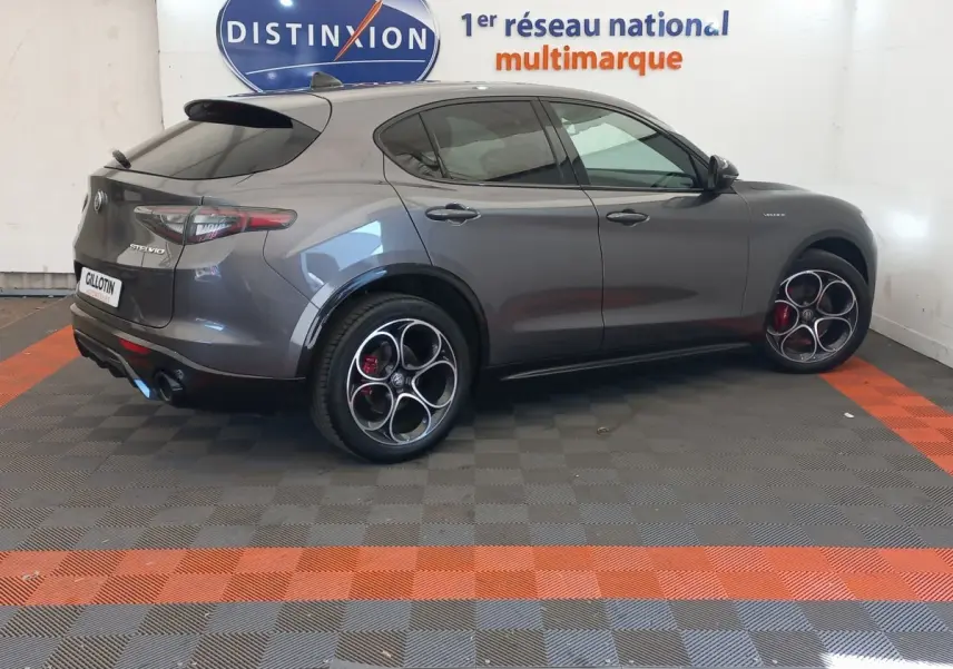 Vue 3/4 arrière droite de l'Alfa Romeo Stelvio gris foncé avec jantes sport distinctives et feux arrière LED.