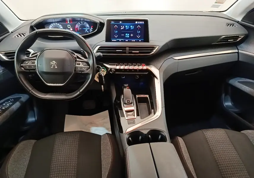 Intérieur Peugeot 3008 noir, vue frontale du poste de conduite avec volant cuir et écran tactile central.