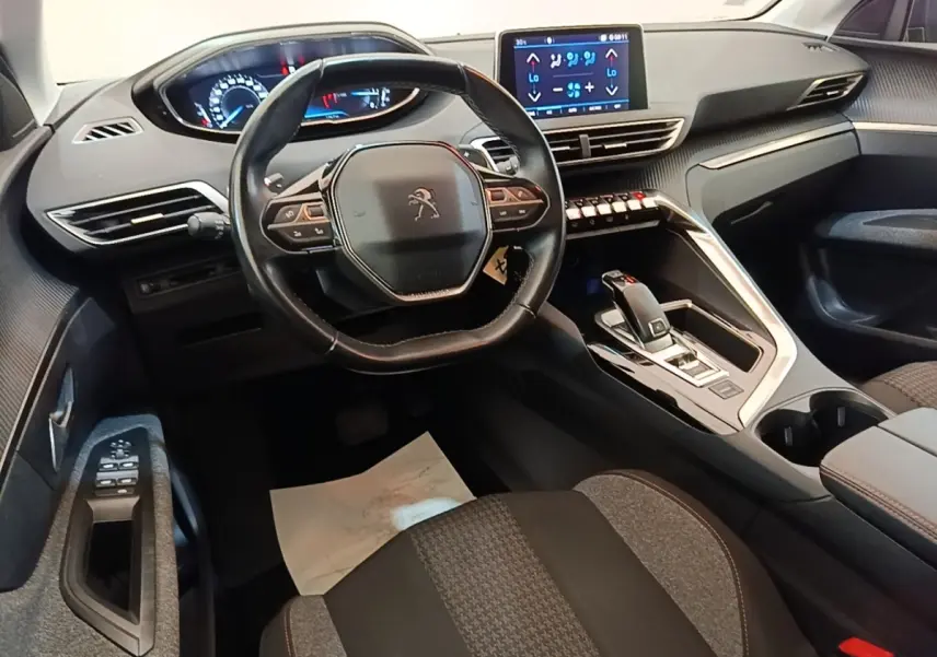 Vue intérieure côté conducteur du Peugeot 3008 noir, volant cuir multifonctions et écran tactile central visible.