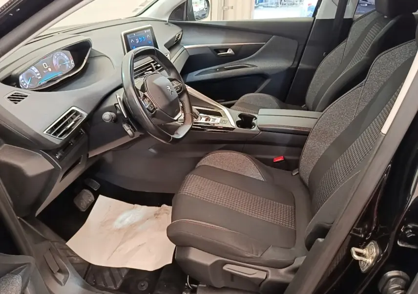 Vue intérieure côté conducteur du Peugeot 3008 noir, mettant en valeur le volant cuir multifonctions et l'écran tactile central.