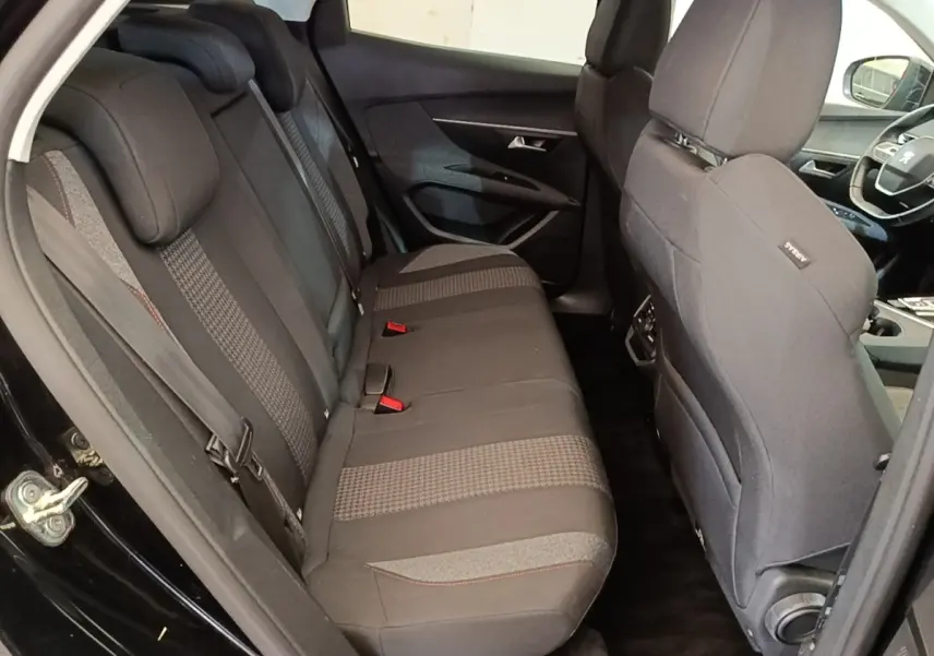 Vue intérieure côté gauche montrant la banquette arrière noire et les sièges avant du Peugeot 3008 noir de 2018.