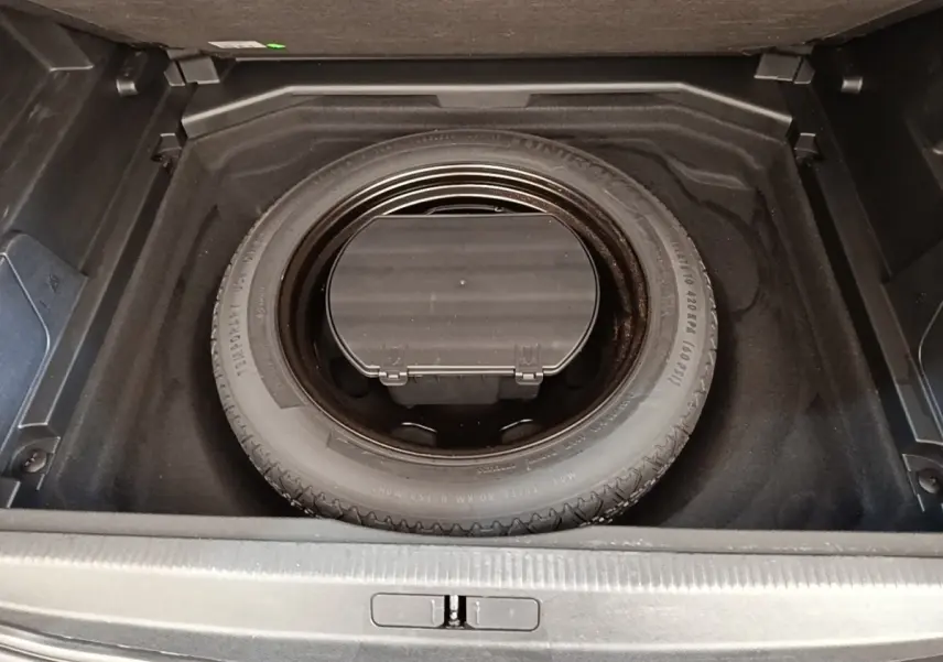 Vue plongeante sur la roue de secours noire dans le coffre d’un Peugeot 3008 noir, version 2018.