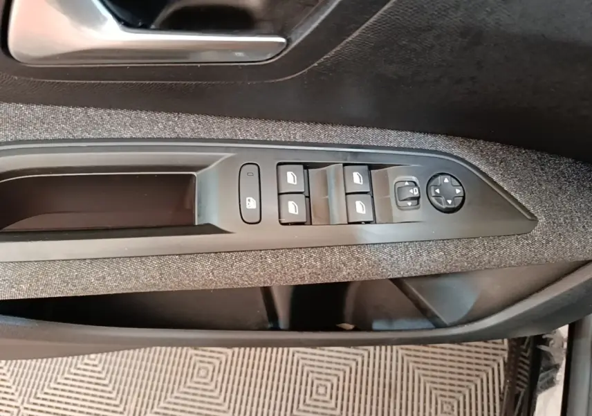 Gros plan sur la commande des vitres et rétroviseurs côté conducteur de la Peugeot 3008 noire, garniture tissu.