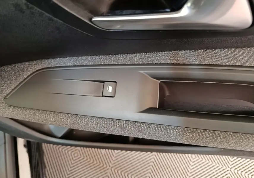 Gros plan sur la poignée intérieure et la commande de lève-vitre côté gauche d’un Peugeot 3008 noir de 2018.