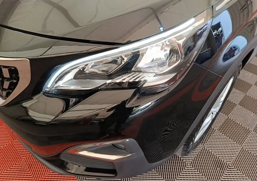 Gros plan sur l'avant droit noir brillant du Peugeot 3008 avec phare LED et calandre partielle visible.
