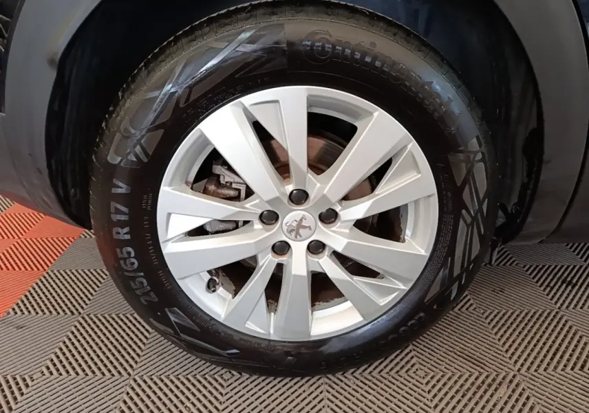 Gros plan sur la jante argentée et le pneu Continental du côté gauche d’un Peugeot 3008 noir.