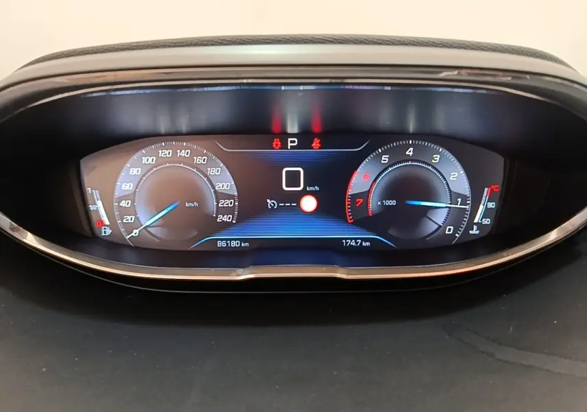 Vue rapprochée du tableau de bord numérique du Peugeot 3008 noir, affichant vitesse, compte-tours et température moteur.