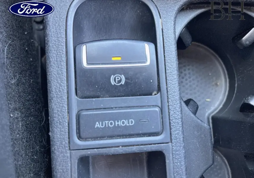 Gros plan sur la commande de frein de stationnement électrique et bouton Auto Hold dans un intérieur de voiture.