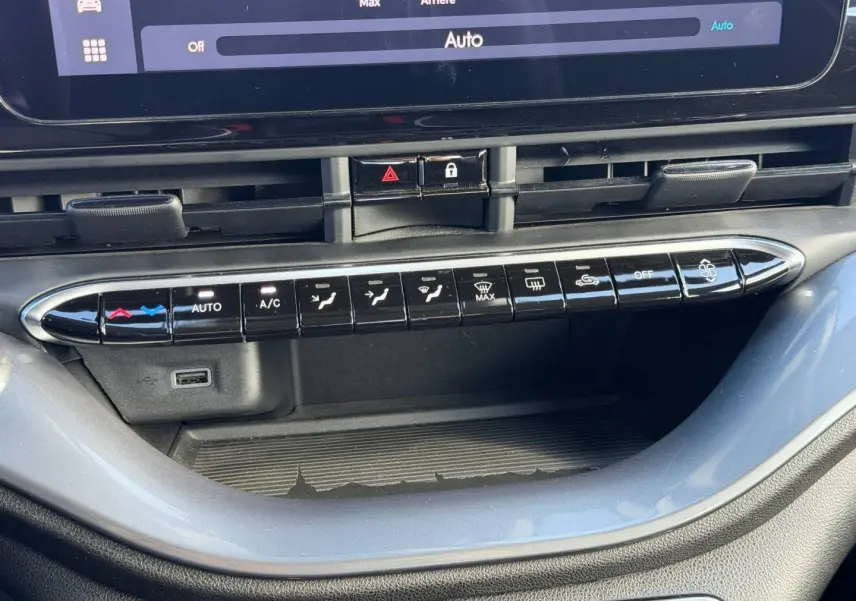 Gros plan sur la console centrale de la Fiat 500 e 118ch MY24 Onyx Black, montrant les commandes climatisation et un port USB.