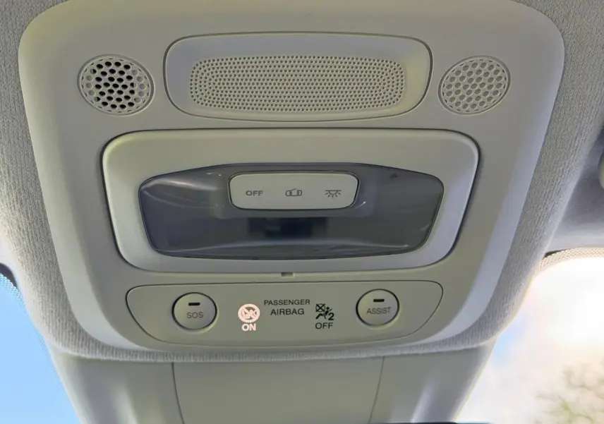 Vue intérieure en gros plan du plafonnier gris clair avec boutons SOS et Assist sur Fiat 500 électrique 2024.