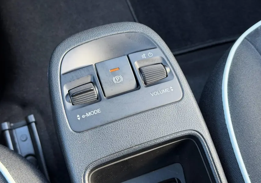 Gros plan sur la console centrale noire de la Fiat 500 e 118ch MY24 avec commandes e-Mode, frein électrique et réglage volume.