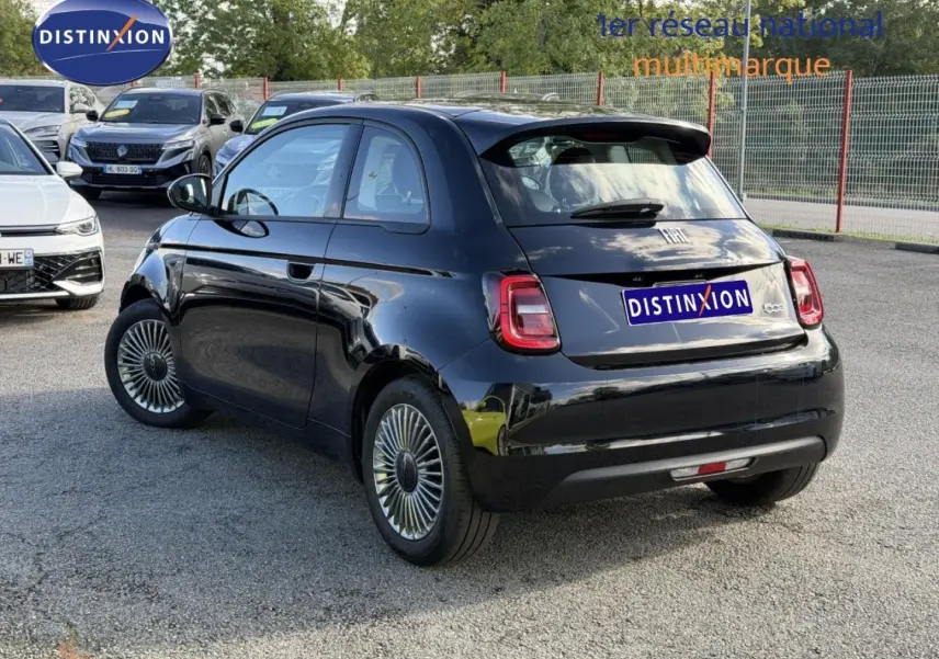 Fiat 500 e 118ch 2024 en Onyx Black pastel vue 3/4 arrière droit, avec feux arrière LED et jantes spécifiques.