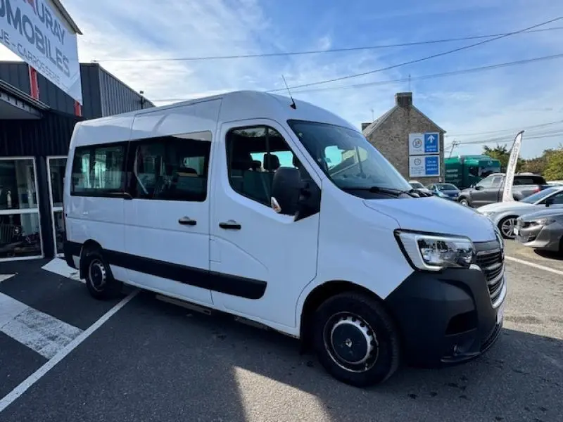Renault Master Combi blanc minéral vu en 3/4 avant droit, avec porte latérale coulissante et vitres teintées.