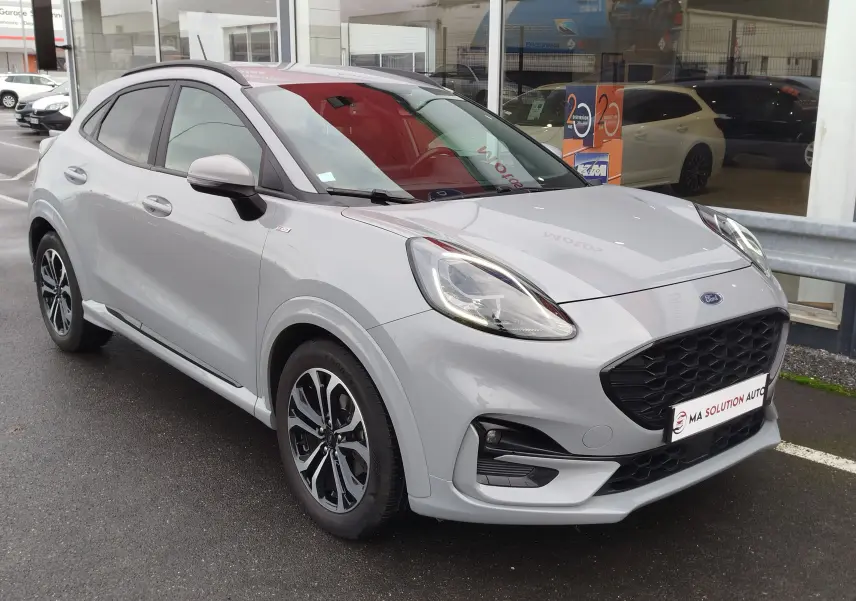 Ford Puma 1.0 EcoBoost 125ch mHEV ST-Line gris Fashion vu en 3/4 avant droit avec jantes bi-ton et calandre noire.