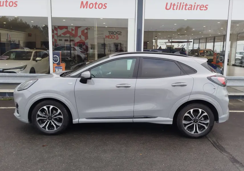 Vue de profil côté gauche du Ford Puma 1.0 EcoBoost gris Fashion Matter avec toit noir et vitres teintées.