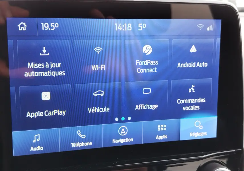 Écran tactile central du Ford Puma 2021 affichant les options connectivité et réglages, avec interface bleue.